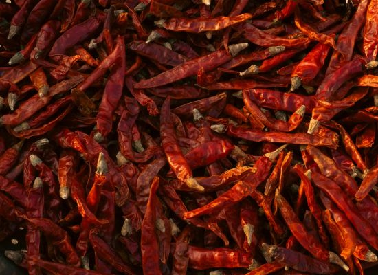 Close-up of a vibrant pile of sun-dried red chili peppers, ready for culinary use.
